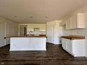 Open-concept kitchen with white cabinets, a large island, and dark wood-look flooring at 1319 Fleming Dr, Greenfield, IN 46140