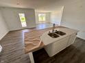 New kitchen island with stainless steel sink, faucet, and an open view of the living room at 1319 Fleming Dr, Greenfield, IN 46140