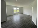 Bright living room featuring gray wood floors, a window, and white walls at 1319 Fleming Dr, Greenfield, IN 46140