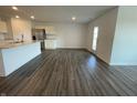 Open concept living area with hardwood floors that connect to the kitchen and a glass door leading to the outside at 1319 Fleming Dr, Greenfield, IN 46140
