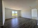 Bright living room with wood-look floors, a window overlooking the front yard, and fresh white walls at 1319 Fleming Dr, Greenfield, IN 46140