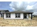 Rear exterior of a modern home featuring a covered porch, white siding and black trim at 1319 Fleming Dr, Greenfield, IN 46140