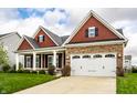 Lovely home showcasing a spacious two-car garage, stone accents, and a neatly kept lawn with lush green grass at 15144 Bentfield Ct, Fishers, IN 46037