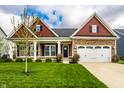 Charming single-Gathering home featuring a stone facade, two-car garage, and a well-manicured front lawn at 15144 Bentfield Ct, Fishers, IN 46037