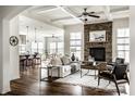 Open-concept living room boasts a stone fireplace, ceiling fan, and seamless flow to kitchen and dining areas at 15144 Bentfield Ct, Fishers, IN 46037