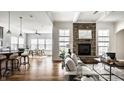 Bright, open living space features a stone fireplace, hardwood floors, and transitions to kitchen and dining spaces at 15144 Bentfield Ct, Fishers, IN 46037