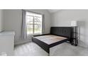 Minimalist bedroom with a platform bed frame and large windows offering natural light, complemented by soft grey walls at 1747 Wellpark Dr, Westfield, IN 46074