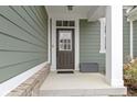 Elegant front door with glass paneling and a modern door lock, surrounded by neutral siding and manicured landscaping at 1747 Wellpark Dr, Westfield, IN 46074