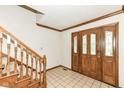Inviting entryway with hardwood floors, staircase, and a decorative wooden front door at 2308 Galahad Dr, Indianapolis, IN 46228
