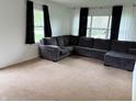 Spacious living room featuring neutral carpet, a large sofa, and natural light from the windows at 2632 Walker Ave, Indianapolis, IN 46203