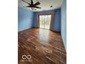 Primary bedroom with laminate flooring, a ceiling fan and sliding glass doors at 38 Homestead Dr, Sheridan, IN 46069