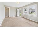 Bright living room features neutral carpet, fresh paint, and natural light at 3826 Delaware St, Anderson, IN 46013