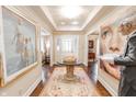 Elegant foyer with tray ceilings, hardwood floors, and refined artwork displays at 411 Sugar Tree Ln, Indianapolis, IN 46260