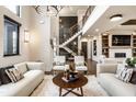 Open-concept living room with white couches, fireplace, and a staircase to the upper level at 4292 Alderborough Way, Zionsville, IN 46077
