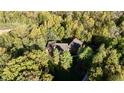 Aerial shot of home nestled in a lush, wooded area with a well-maintained yard and a large roof at 5528 State Road 144, Greenwood, IN 46143