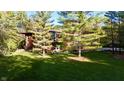 Beautiful front exterior view with well-manicured lawn, mature trees and attractive landscaping in a wooded area at 5528 State Road 144, Greenwood, IN 46143