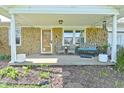 Inviting covered front porch with stone accents, seating area, and decorative plants at 5693 W Walnut St, Greenwood, IN 46142