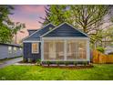 Charming home with a screened porch, blue siding, and well-maintained landscaping at 6106 Evanston Ave, Indianapolis, IN 46220