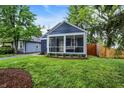 Charming home with a screened porch, blue siding, and well-maintained landscaping at 6106 Evanston Ave, Indianapolis, IN 46220