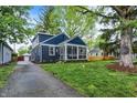 Two-story home featuring blue siding, a screened porch, and a long driveway at 6106 Evanston Ave, Indianapolis, IN 46220