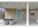 Close up of the covered porch, showing decorative planters, lighting, and the blue front door at 6194 Evanston Ave, Indianapolis, IN 46220