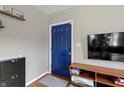 Modern entryway with a blue door, shoe cabinet, and a media center at 6194 Evanston Ave, Indianapolis, IN 46220