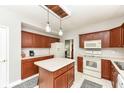 Well-lit kitchen featuring cherry cabinets, a center island, and modern appliances at 693 Prince Dr, Greenwood, IN 46142