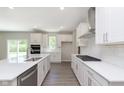 Modern kitchen with stainless steel appliances, white cabinetry, and island sink at 7215 Barrett Dr, Brownsburg, IN 46112