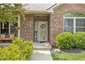 Inviting front porch with charming decor, a cozy bench, and a beautifully landscaped entrance at 7340 Stones River Dr, Indianapolis, IN 46259
