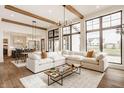 Bright living room with large windows, hardwood floors, exposed beam ceiling, and a large white sectional sofa at 8082 Abington Way, Zionsville, IN 46077