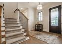 Elegant foyer with hardwood floors, carpeted stairs, wood banister, and a view to the exterior at 8092 Abington Way, Zionsville, IN 46077