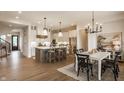 Open-concept kitchen and dining area with stainless steel appliances, island and white cabinetry at 8092 Abington Way, Zionsville, IN 46077