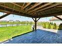 Covered patio with a view of the backyard, a pond, and surrounding houses at 8163 Dewberry Ln, Pendleton, IN 46064