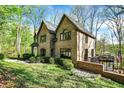 Backyard showing brick retaining wall with deck and lower patio overlooking green space and lake at 8191 S Bayview Ct, Trafalgar, IN 46181