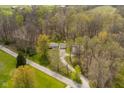 Elevated view of a home, garage, and shed with verdant trees along a paved road at 9570 S 300 W, Columbus, IN 47201