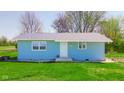 Charming single-story home featuring blue siding, a well-kept lawn, and mature trees at 1004 Shepherd Rd, Anderson, IN 46012
