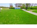 An exterior view of the home from the side yard showcasing ample greenery at 1004 Shepherd Rd, Anderson, IN 46012