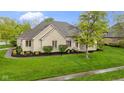 Beautifully landscaped home featuring a manicured lawn and mature tree at 10794 Pine Needle Ct, Fishers, IN 46037