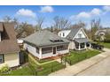 Attractive home with a screened porch, set on a well-manicured lot with green grass and mature trees at 1114 N Mount St, Indianapolis, IN 46222