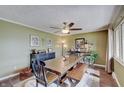 This dining room features wood floors, a ceiling fan, a table with chairs, and unique décor at 120 Crosby Dr, Indianapolis, IN 46227