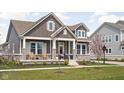 Charming two-story home with stone accents, inviting front porch, and manicured lawn at 1230 Amberley Way, Westfield, IN 46074