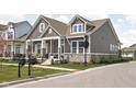 Charming two-story home with stone accents, inviting front porch, and manicured lawn at 1230 Amberley Way, Westfield, IN 46074