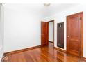 View of bedroom with hardwood floors, neutral walls, and wooden doors at 1726 N Euclid Ave, Indianapolis, IN 46218