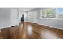 Bright living room showcasing hardwood floors, neutral paint and open layout with natural light from multiple windows at 1819 S Drexel Ave, Indianapolis, IN 46203