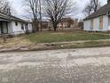 Street view of a property showing a grassy area between two homes and a vacant lot at 1924 E Maryland St, Indianapolis, IN 46201