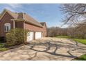 Spacious driveway leading to a three-car garage, surrounded by lush greenery and mature trees, providing ample parking at 1937 Knightsbridge Rd, Danville, IN 46122