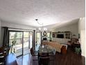 Open concept living room with a glass table, dark wood floors, and natural light at 21 Osage Ct, Columbus, IN 47201