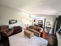 Spacious living room with a plush carpet, clerestory window, and staircase at 21 Osage Ct, Columbus, IN 47201