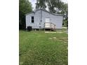 Back exterior with simple back door and a well maintained lawn at 2413 N Macedonia Ave, Muncie, IN 47303