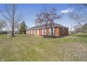 A charming brick home featuring a red front door, complimented by lush greenery at 2526 David Dr, Westfield, IN 46074